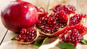 pomegranate with leafs on wooden table