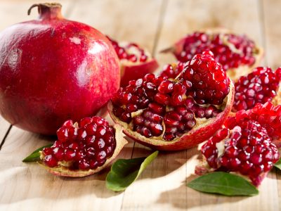 pomegranate with leafs on wooden table